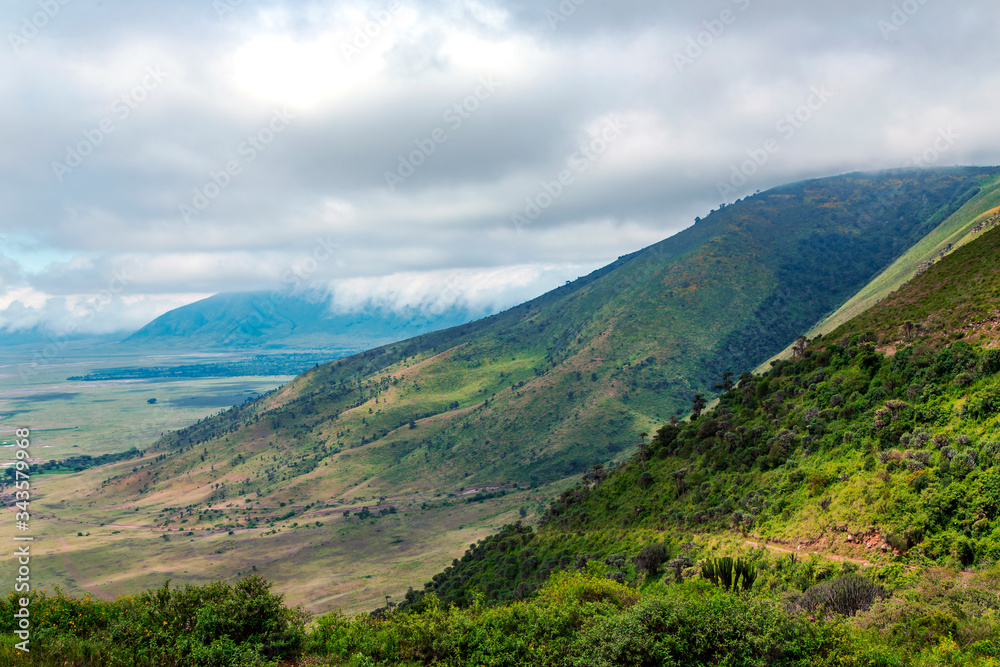Ngorongoro valley with mountains in the background on a cloudy day, Tanzania, Africa