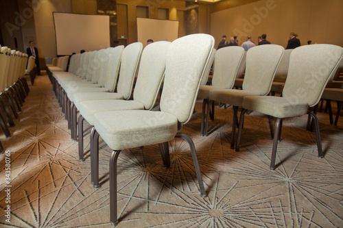 White chairs in the conference room. empty seat in conference meeting hall . White Chairs in the Conference Room just before a business meeting takes place. © Adil