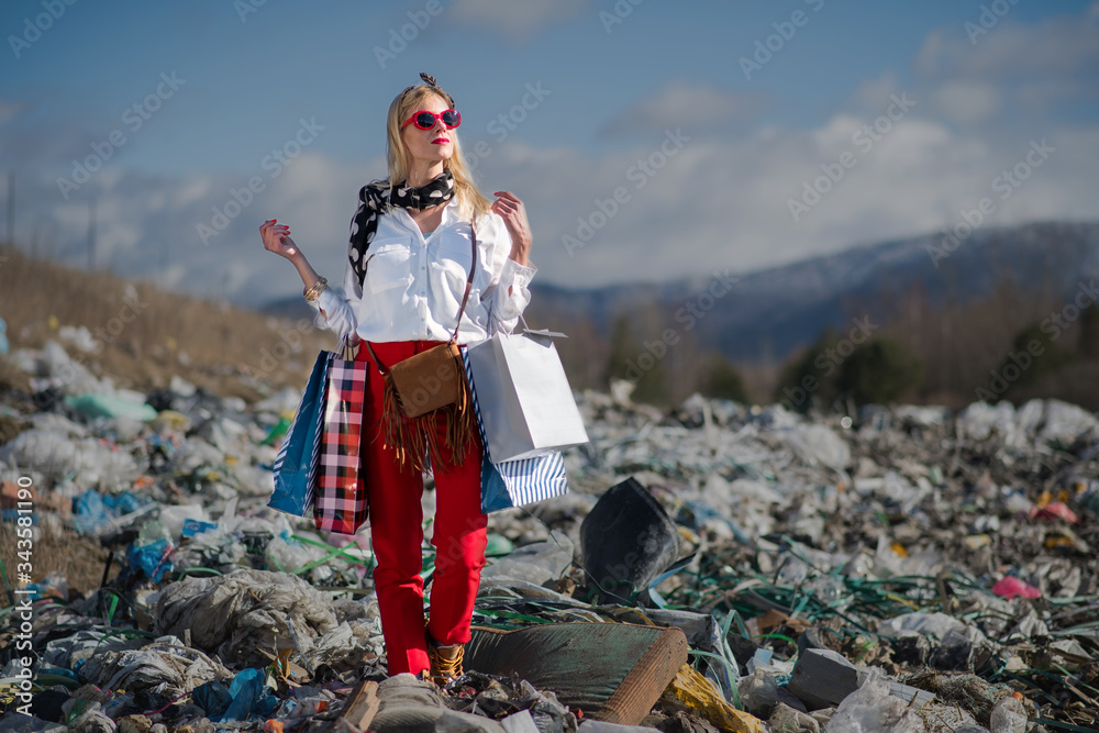 Modern woman on landfill, consumerism versus pollution concept. - obrazy, fototapety, plakaty 