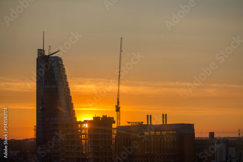 Building construction contrasted by sunset in orange tone, London UK.
