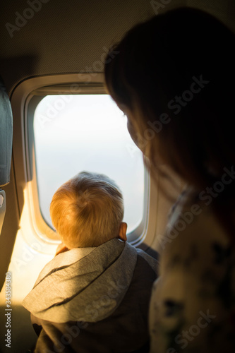 little boy travel by plane looking through window