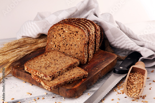 Sliced rye bread on cutting board. Whole grain rye bread with seeds on table