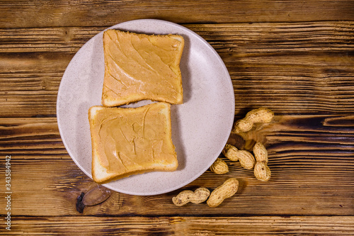 Sandwiches with peanut butter in plate on a wooden table. Top view