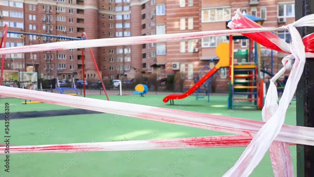playground is closed by striped red and white tape fencing for quarantine during coronavirus epidemic.Kiev,Ukraine, March 31,2020 playground is closed by striped red and white tape fencing for quarantine during coronavirus epidemic.Kiev,Ukraine, March 31,2020