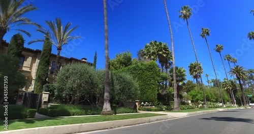 Driving in tropical Beverly Hills next to movie celebrities homes with palm trees in Los Angeles, California, 4K