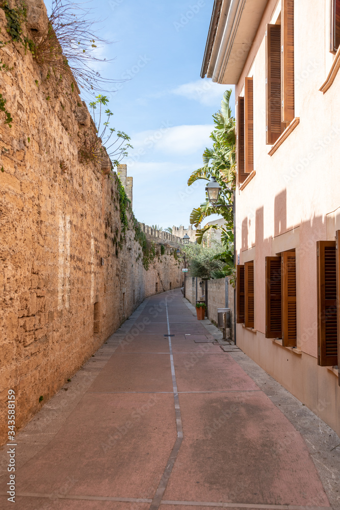 enge Gasse durch eine Dorf in Spanien vorbei an einer alten Stadtmauer