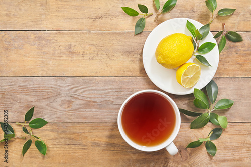 Tea with lemon on wooden table background with copy space. Top view.