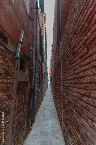 Really narrow alley with brickwalls on the sides in Venice photo