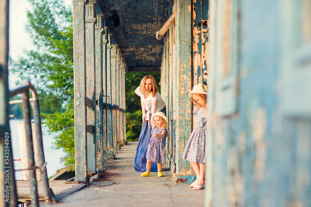 Naklejka premium mom and kids standing on porch of old wooden house