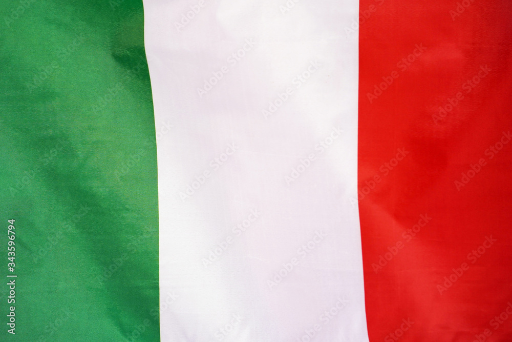Obraz premium Fabric texture flag of Italy. Flag of Italy waving in the wind. Italy flag is depicted on a sports cloth fabric with many folds. Sport team banner.