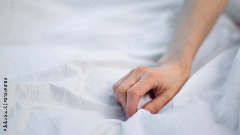 Close up seductive female hand touching soft white sheet. Shot on RED Raven 4k Cinema Camera Close up seductive female hand touching soft white sheet. Shot on RED Raven 4k Cinema Camera