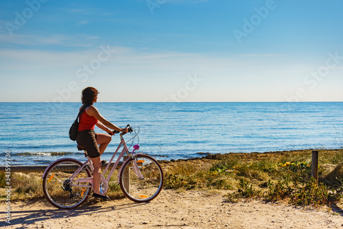 Woman ride bicycle on beach, active lifestyle.