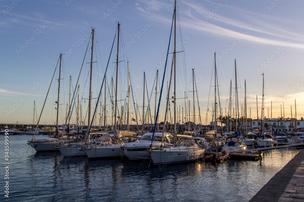 Yachts in puerto de mogan harbour baithed in warm evening light