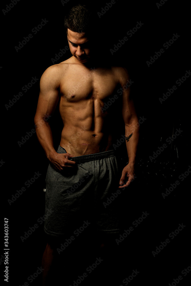 Fototapeta premium Homem com corpo definido e musculoso, treinando para competições de musculação