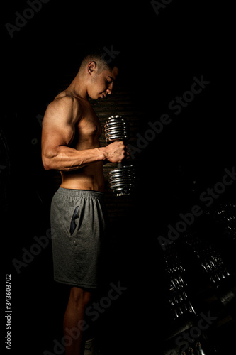 Homem com corpo definido e musculoso, treinando para competições de musculação