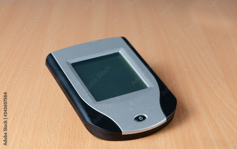 Close-up of old touchscreen personal digital assistent (PDA) on wooden background , representative concept of an old technology that is no longer current . Close-up of old touchscreen personal digital assistent (PDA) on wooden background , representative concept of an old technology that is no longer current .