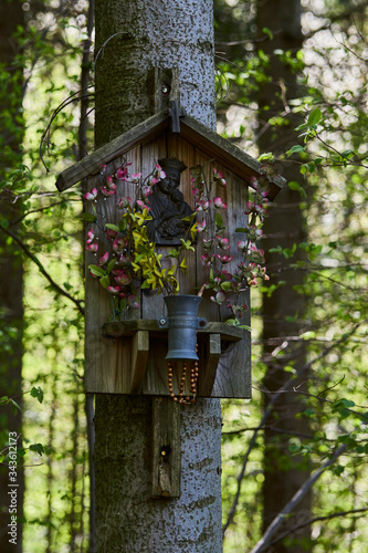 A moody chapel in the middle of the forest hung on a tree