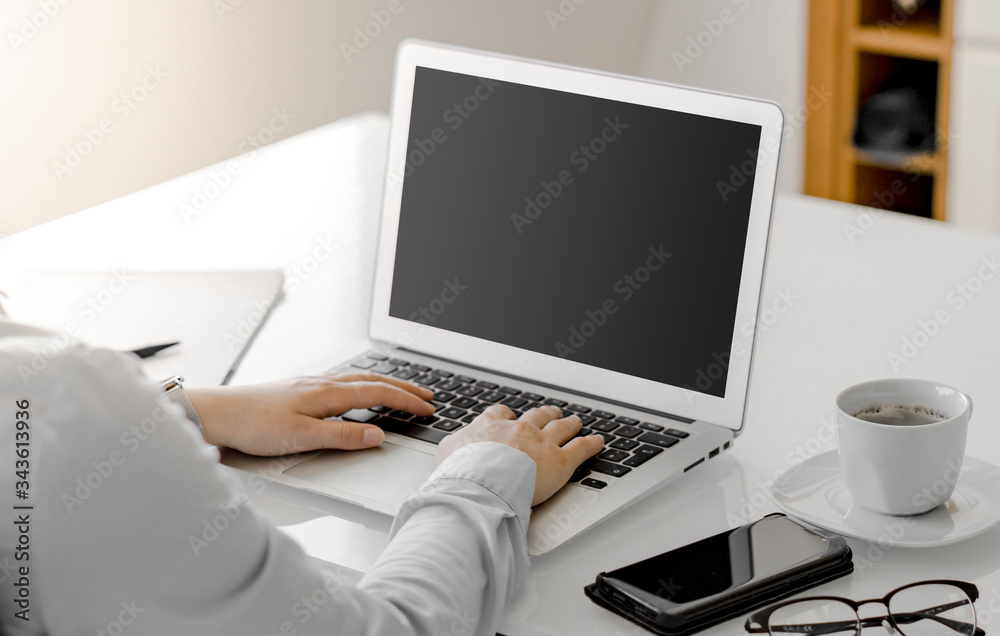 Working on a Notebook computer in Home office or regular Office with blank screen for filling in the own website or something else Working on a Notebook computer in Home office or regular Office with blank screen for filling in the own website or something else