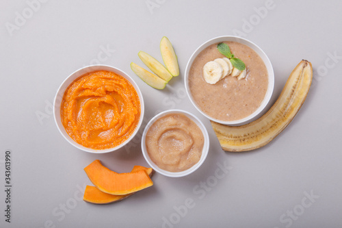 Bowls with healthy baby food on color background. Purees, made of fresh organic fruit and vegetables, flay lay, top view, concept. Kids meal