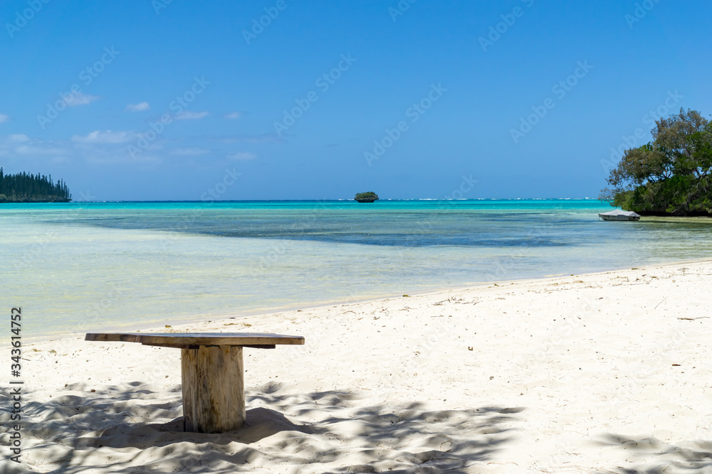 isolated wooden table on a paradisiac beach. sky is blue and water aquamarine isolated wooden table on a paradisiac beach. sky is blue and water aquamarine