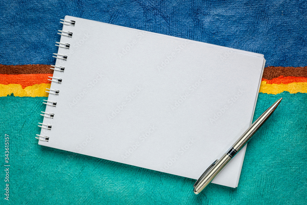 blank art sketchbook against colorful handmade paper blank art sketchbook against colorful handmade paper