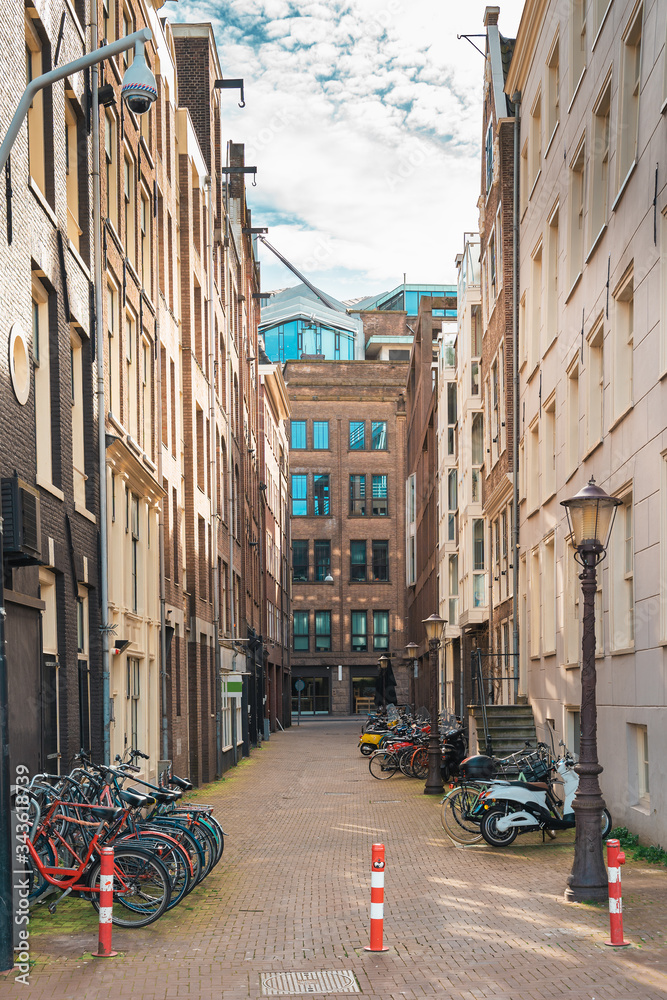 Typical narrow street in Amsterdam with dancing houses and bikes, Netherlands.