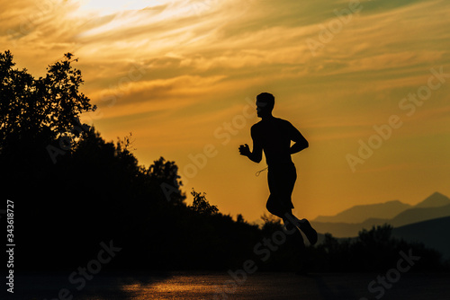 Muscular silhouette fit sport model sprinter exercising sprint at mountain