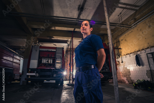 Portrait of female firefighter standing against firetruck at station