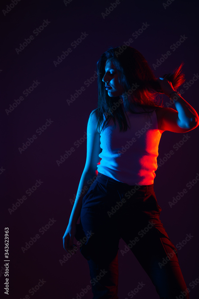Blue and red light portrait of a female model on a black background with high contrast