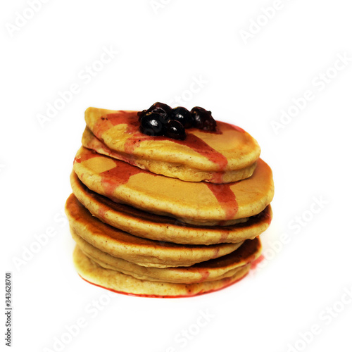 Stack of pancakes with blackcurrant at the top, isolated on white background