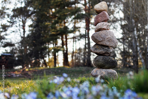Canvas Print tower of stones standing on top of each other on a background of trees