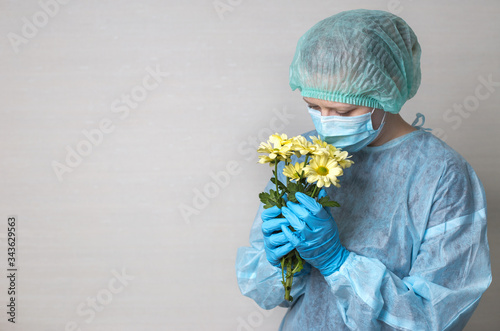 woman doctor in protective suit with flowers