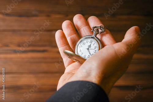 a pocket watch in the hands of a man