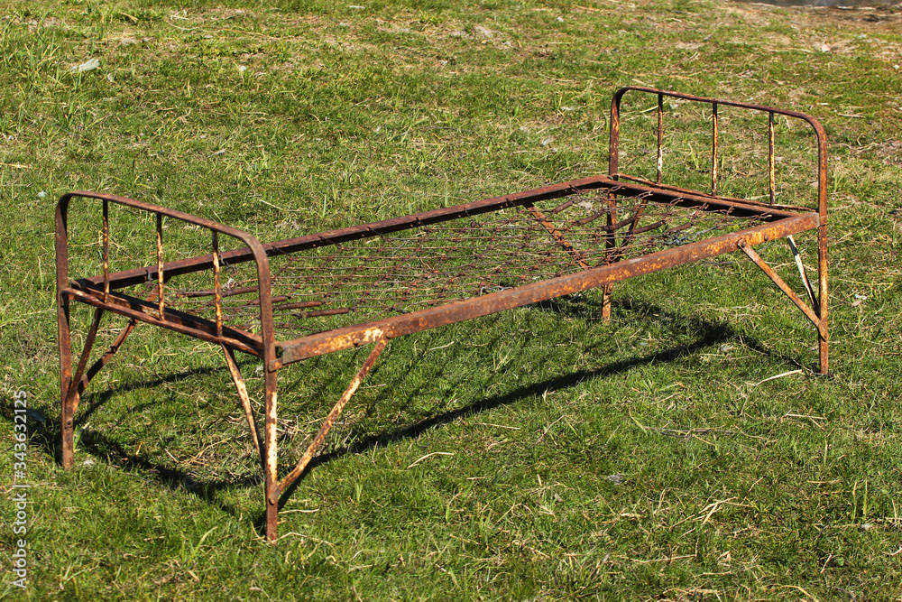 Old rusty spring bed on green grass Old rusty spring bed on green grass