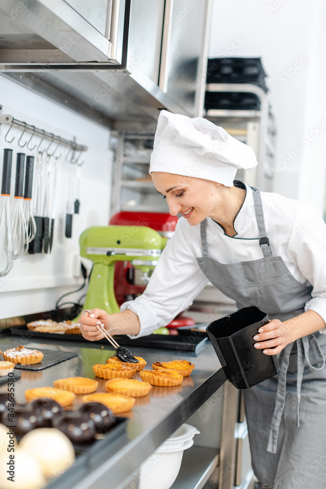 Pastry chef glazing little cakes Pastry chef glazing little cakes