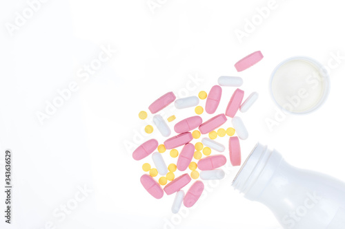 Pills spilling out of pill bottle. Assorted pharmaceutical medicine pills, tablets and capsules on white background. Antiretrovirals on white background.