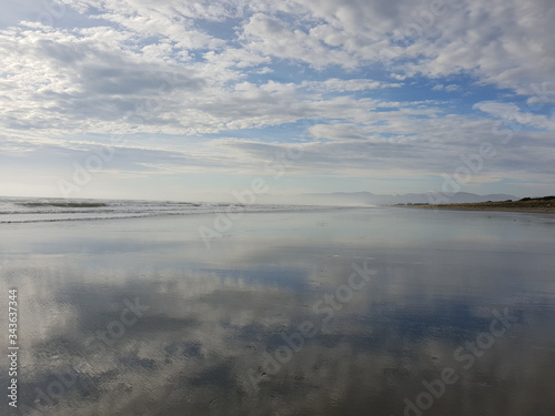 Reflections of a cloudy sky on a calm beach landscape. Waimairi Beach, Christchurch.
