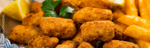 Crispy Fish Bites Snack Size. Deep Fried Pollock Fish Fingers with Tartar Dipping Sauce. Selective focus. photo