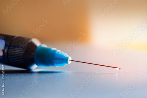 Drop on the tip of the syringe. Focus on dropplet photo