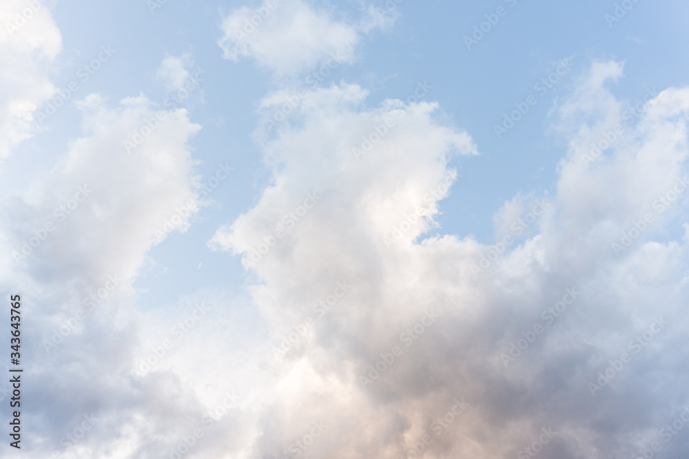 Pastel blue   sky background with fluffy  clouds 