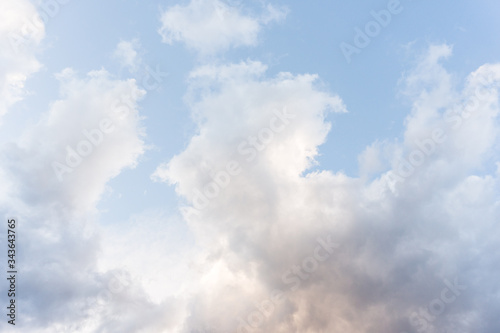 Pastel blue sky background with fluffy clouds 