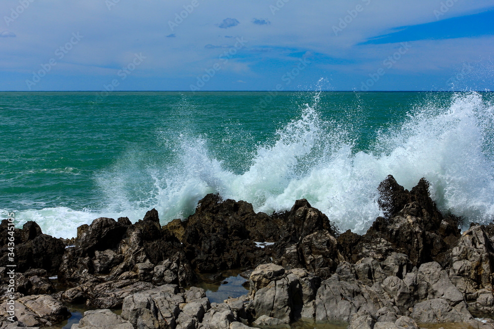  Sea waves crash and splash on rocks. 