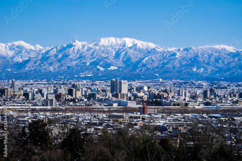 雪景色富山市街地と北アルプス 真冬の薬師岳冠雪