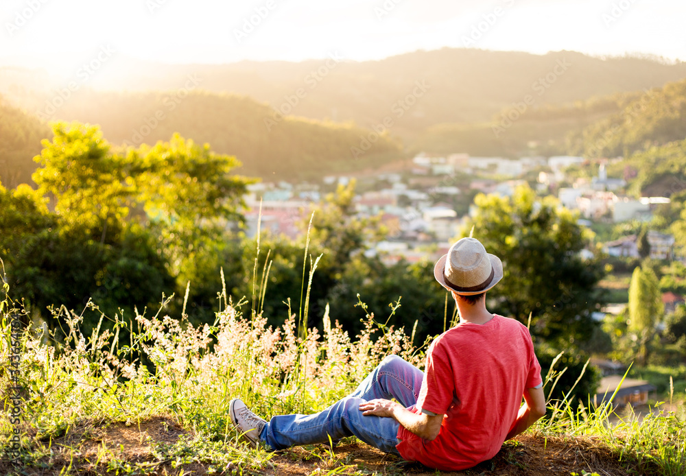 Young man sitting contemplating the landscape. Feeling free, with sunset in the background
Young man sitting contemplating the landscape. Feeling free, with sunset in the background