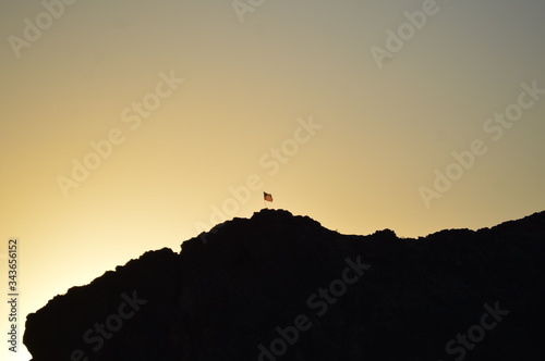 American flag on cliff in sunset