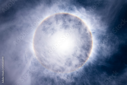 The Sun, with an amazing halo around the sun created by light refraction because of ice crystals on the upper atmosphere layers in the troposphere that create this circumscribed circular sun halo 