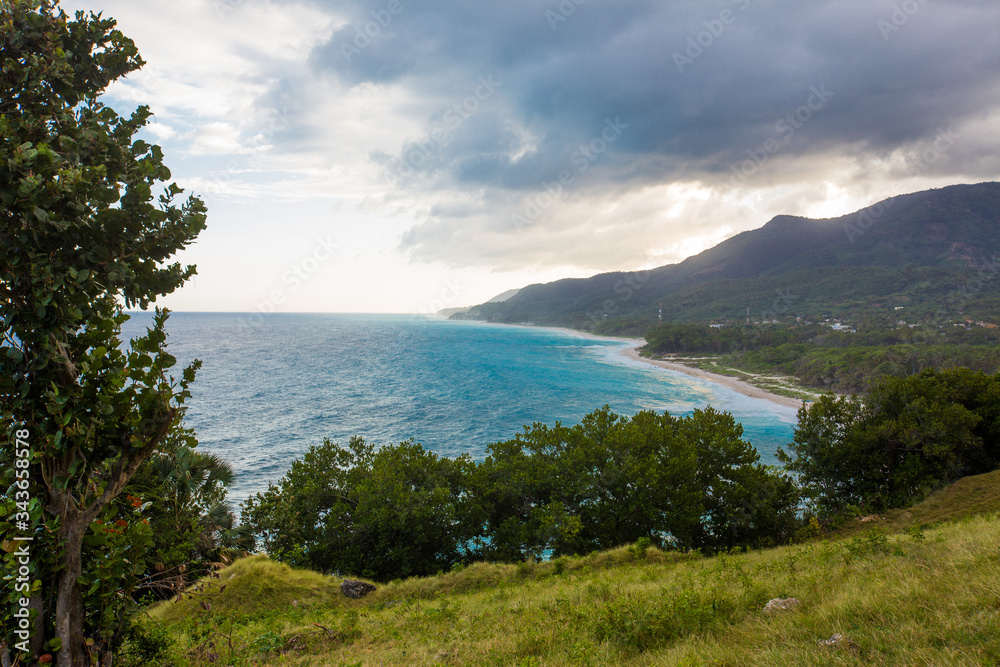 Meadow sea sky cliff landscape at Caribbean coast with green forest  rocks and dramatic clouds in Dominican republic