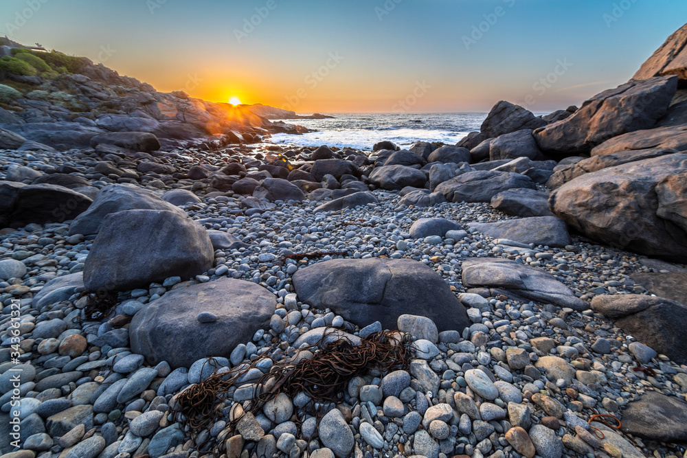 An amazing view of the sunset over the water in the Chilean coast. An idyllic beach scenery with the sunlight illuminating the rocks with orange tones and the sea in the background under a moody sky
An amazing view of the sunset over the water in the Chilean coast. An idyllic beach scenery with the sunlight illuminating the rocks with orange tones and the sea in the background under a moody sky