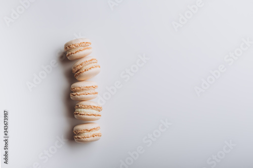 Five beige vanilla Macaroons on a white background 