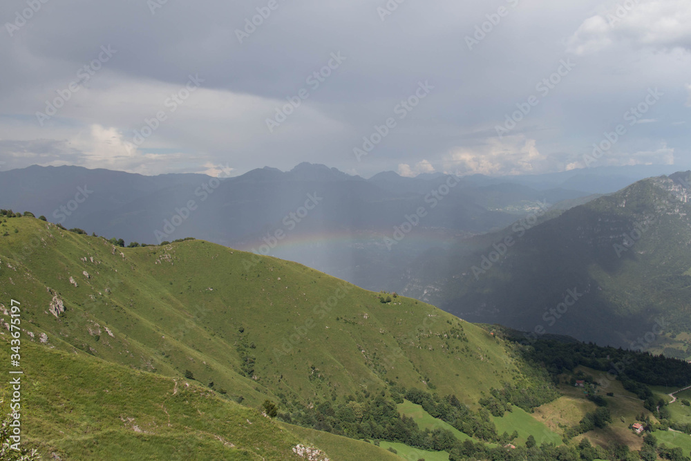 Rainbow over mountains in a sunny day.